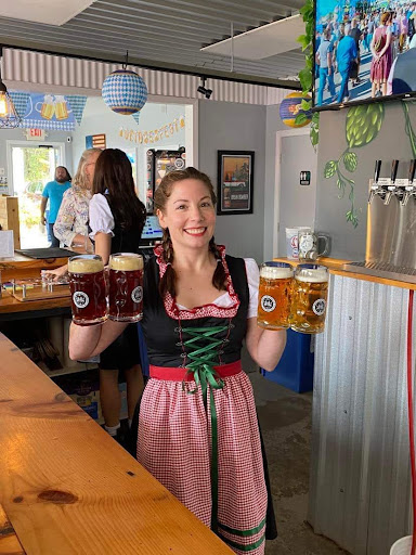 Color photo of Sophia carrying four beer steins